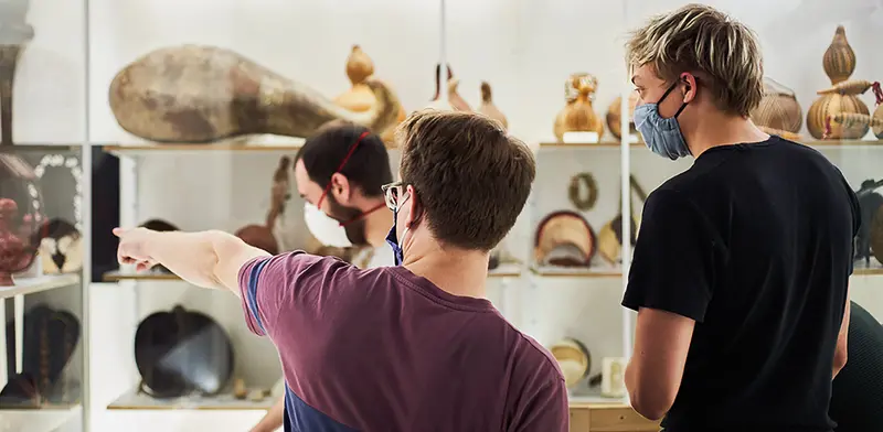 Ein Besucher weist auf ein Museumsexponat auf 