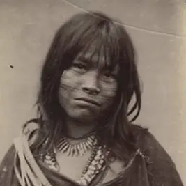 Portrait einer Frau mit dunklen Haaren und mehreren Ketten