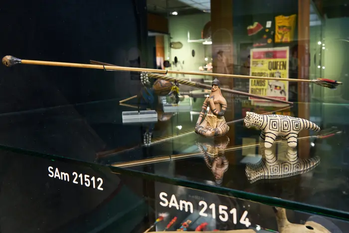 Ausstellungsvitrine mit kleinen geschnitzten Figuren