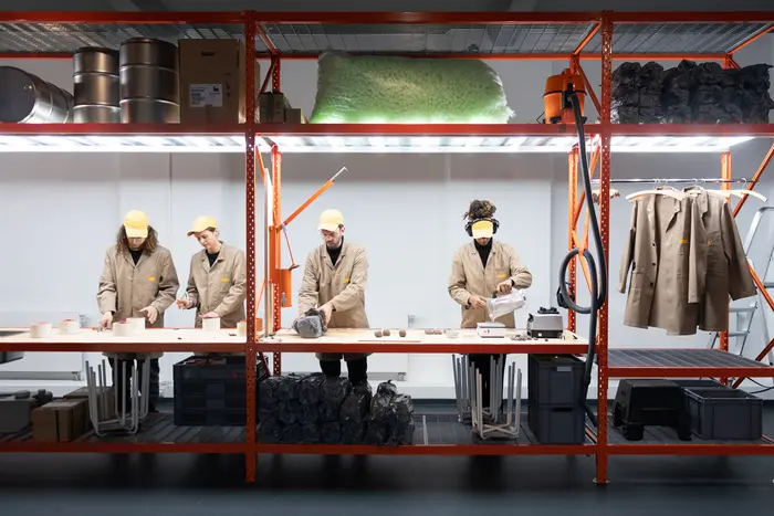 Menschen in Overalls arbeiten an einem Gerüst