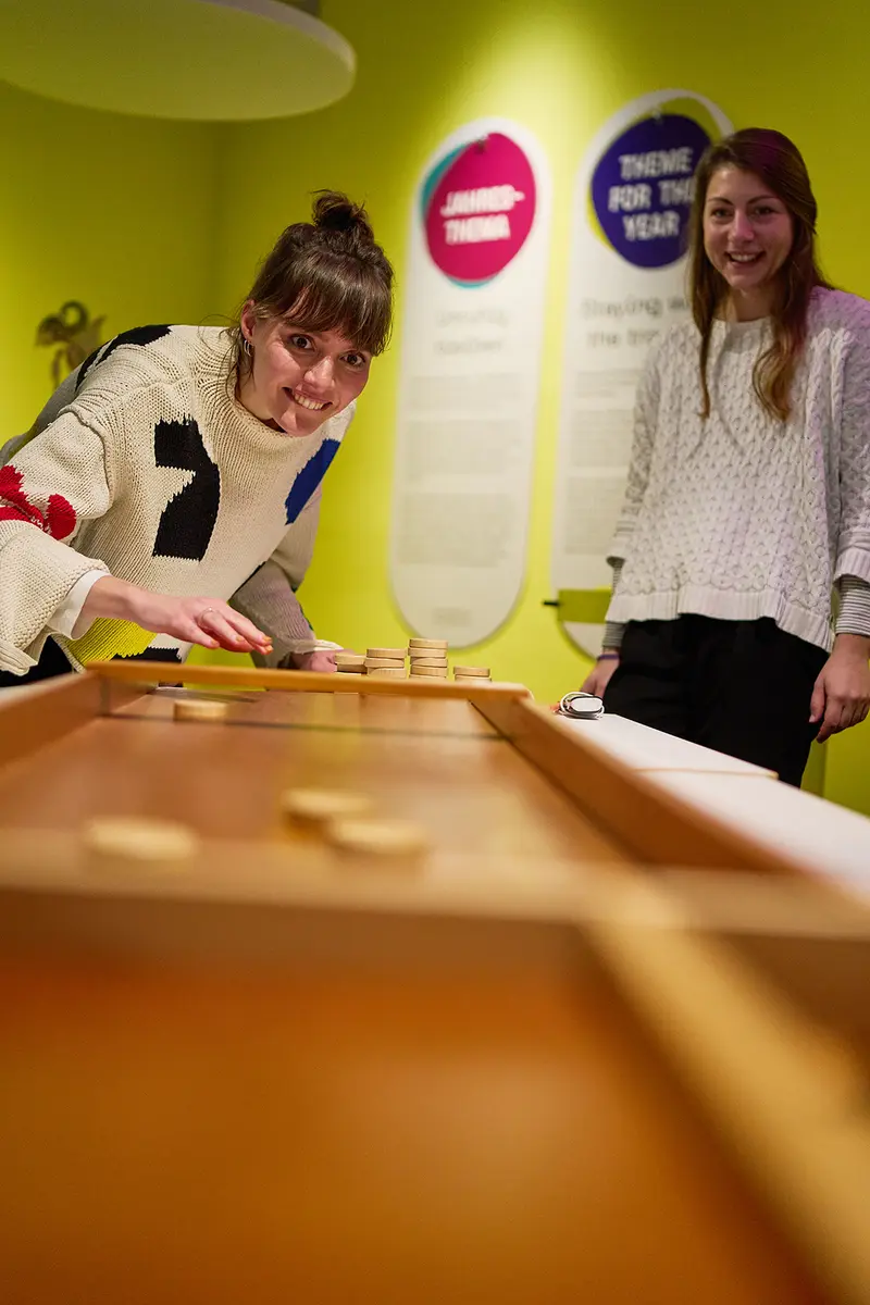 Zwei Besucherinnen spielen ein Spiel