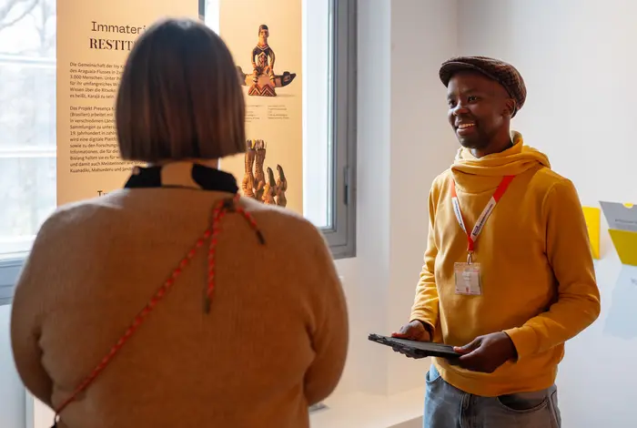 Ein Live Speaker spricht mit einer Frau innerhalb der Ausstellung 