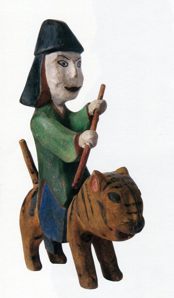 Holzskulptur eines Reiters auf einem Tiger