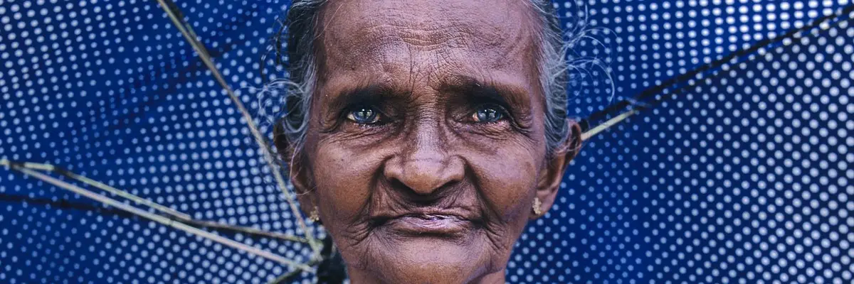 Bild einer alten Frau mit blauen Regenschirm